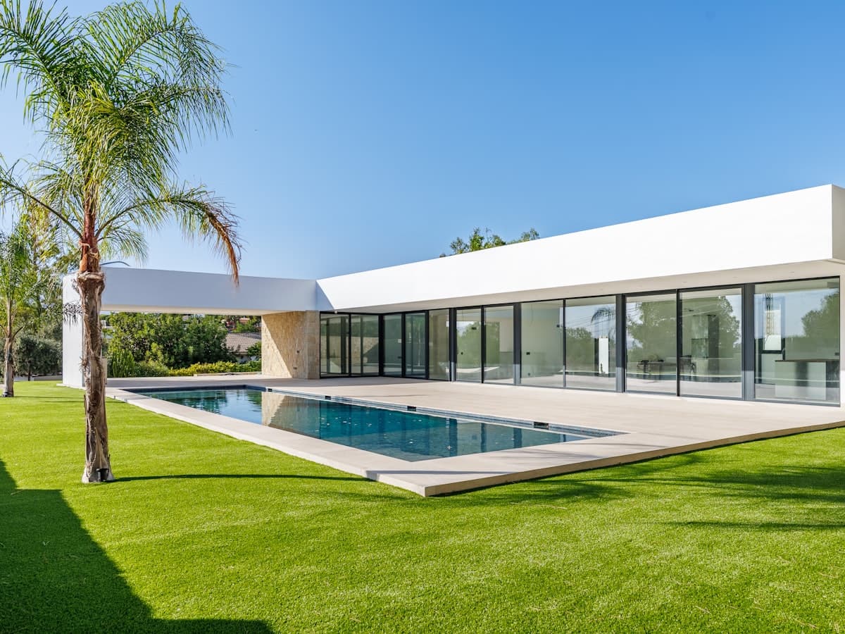 Villa blanca con piscina y palmera